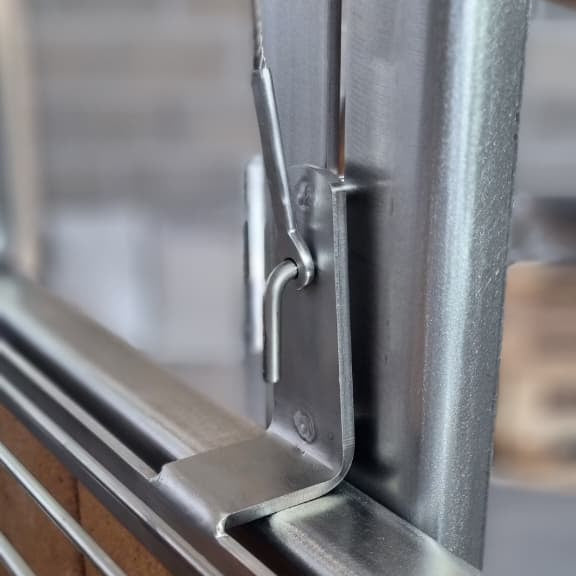 Grill carriage guide with a hook for a cable terminal