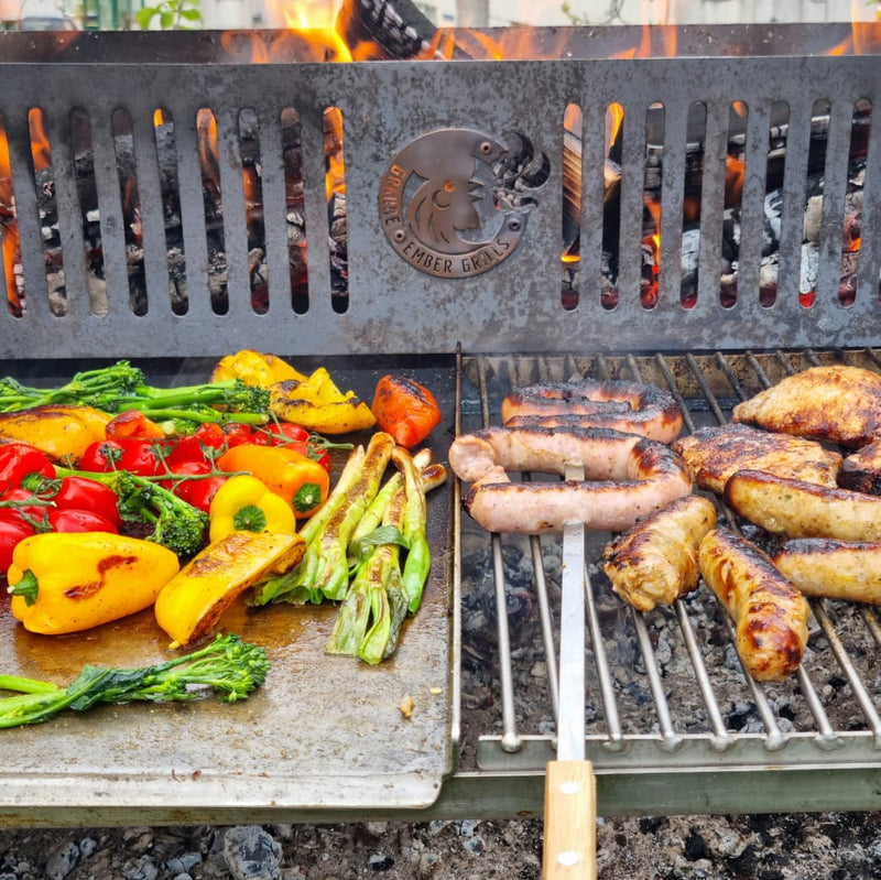 Vegetables on the Plancha and flame grilled sausage sizzling away on the Standard Grate