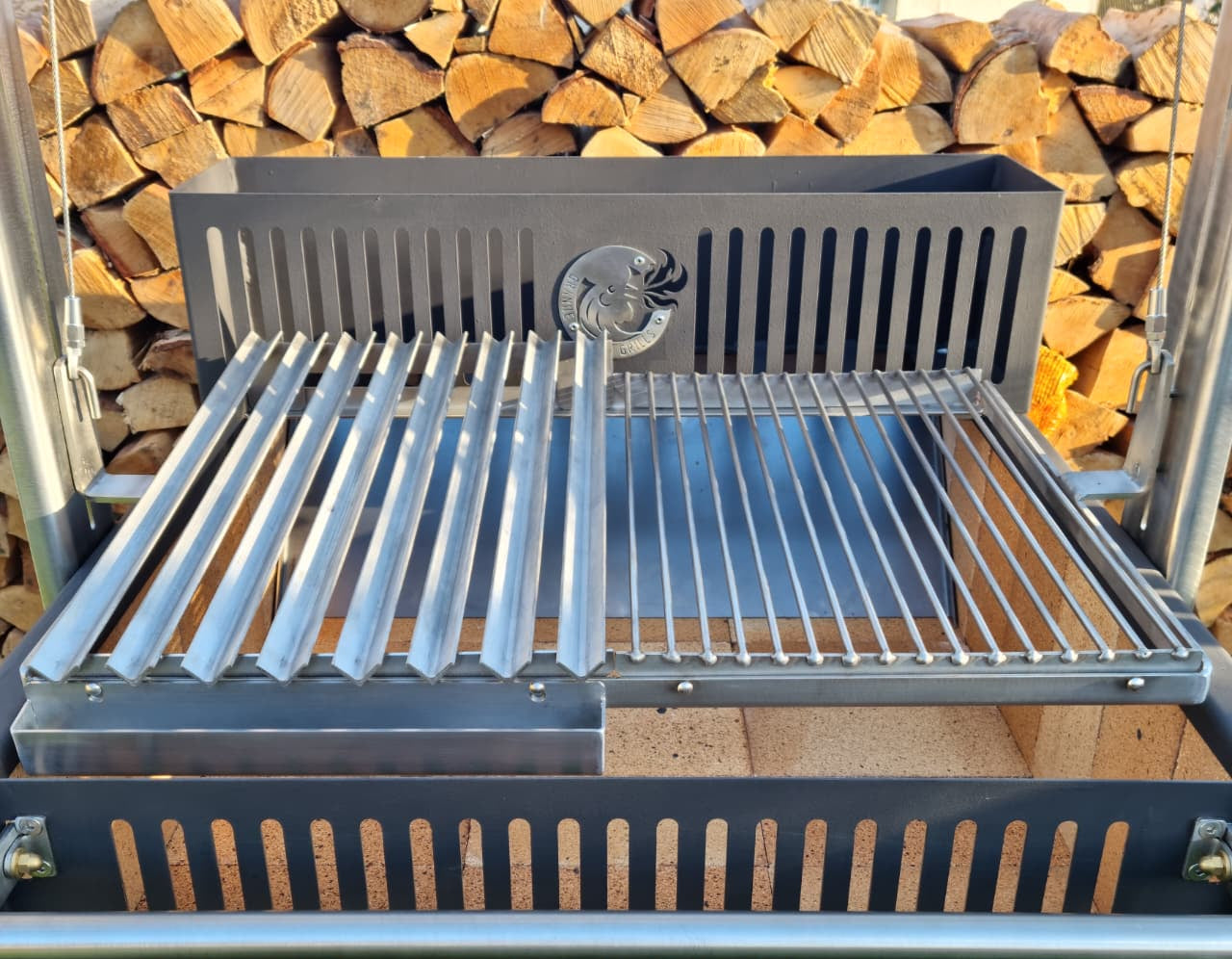 Argentinian grill with a V-grate and grill combo and wooden logs in the background