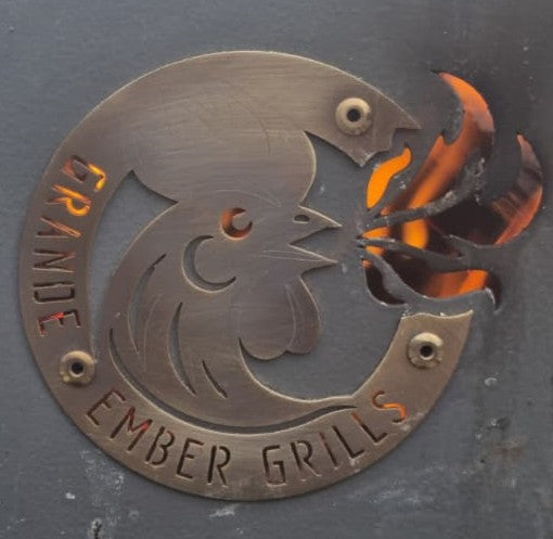 Metallic logo of a rooster with flames and 'Grande Ember Grills' text on a dark background