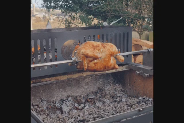 Load video: big slowly rotating chicken over a hardwood fire
