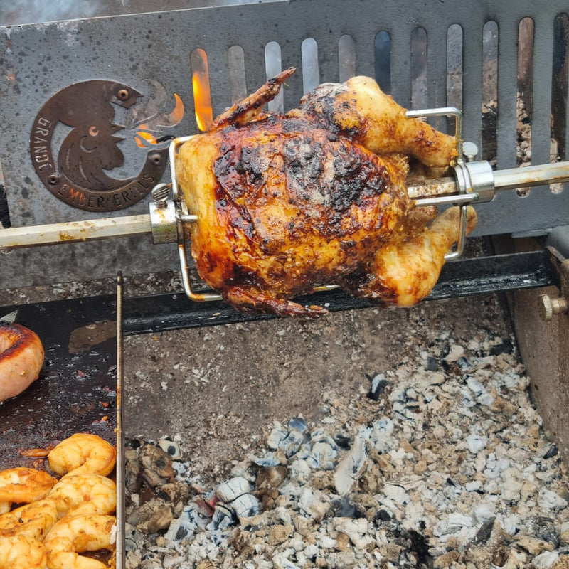 Roasted chicken on a rotisserie over red hot coals